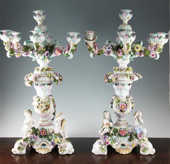 A pair of large German flower encrusted porcelain seven light candelabra, late 19th century, 67.5cm, some repairs and losses